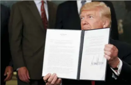  ?? ALEX BRANDON — THE ASSOCIATED PRESS ?? President Donald Trump holds up a signed memorandum calling for a trade investigat­ion of China, Monday in the Diplomatic Reception Room of the White House in Washington.