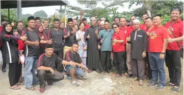  ??  ?? Democratic Action Party (DAP) Sarawak Socialist Youth publicity secretary Abdul Aziz Isa (front, fifth right) with party members and villagers at Kampung Sandong.