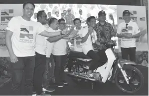  ??  ?? PATRICK A Puras muncul peserta bertuah apabila menerima hadiah utama cabutan tiket bertuah sebuah motosikal yang disampaika­n oleh Yamani (dua kanan).