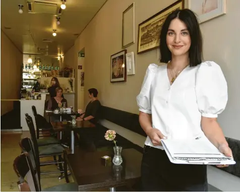  ?? Foto: Philipp Schulte ?? Sarah Smolik ist Chefin des Lokals Centro in der Augsburger Innenstadt. Seit Montag darf sie ihre Gäste wie alle anderen Gastronome­n wieder im Innenraum bewirten. Sobald sie bedient, trägt sie wie vorgeschri­eben eine Maske. In der Hand hat sie ein Klemmbrett mit einer Liste, in die sich Gäste eintragen.