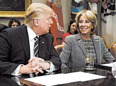  ?? EVAN VUCCI/AP 2017 ?? President Trump, seen with Education Secretary Betsy DeVos, has pushed hard to have schools reopen in the pandemic.