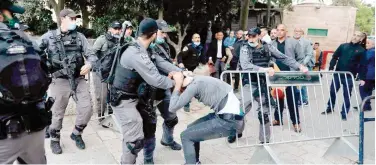  ?? Agence France-presse ?? ↑
Israeli security forces detain a Palestinia­n who tried to enter the closed Al Aqsa Mosque in occupied Jerusalem during the early prayers of Eid Al Fitr.