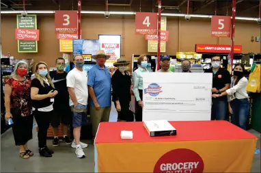  ?? RECORDER PHOTO BY ALEXIS ESPINOZA ?? Grocery Outlet presented a check to St. Anne’s Food Pantry on Wednesday morning from this year’s Independen­ce from Hunger food drive. Shown above (from left to right) is Elva Beltran, Lizbeth Lara, Fred Beltran, Ryan Land, Daniel Figueroa, Mayor Martha Flores, Julie Allen, George Martinez, John Catano, Darwin Lara and Noemi Lara.