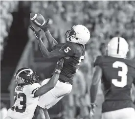  ?? THE ASSOCIATED PRESS ?? Penn State’s DaeSean Hamilton catches a pass over Michigan’s Tyree Kinnel during the first half of Saturday’s game in State College, Pa. Penn State won 42-13.