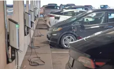  ?? CHRIS PIETSCH/THE REGISTER-GUARD ?? Electric cars sit at charging stations in a parking garage in Eugene.
