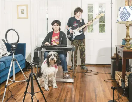  ?? ELI DURST/THE NEW YORK TIMES PHOTOS ?? Noah Faulkner practices with his pedal steel guitar at home with his brother, Nate, on bass and their dog, Kara, on March 18 in Austin, Texas.