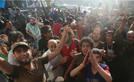  ?? ABDALRHMAN ISMAIL/REUTERS ?? Rebel fighters and Aleppo residents celebrate on Saturday after rebels claimed to have broken a government siege of rebel-held areas.