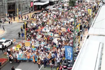  ?? — AFP photo ?? School children march up Lambton Quay to Parliament during a strike and protest by students highlighti­ng inadequate progress to address climate change at Civic Square in Wellington .