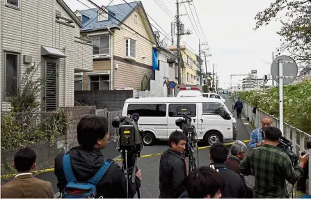  ??  ?? Grisly discovery: Journalist­s and TV cameramen waiting near the apartment partially covered with a blue sheet where police found the nine bodies in Zama, Kanagawa prefecture. — AFP