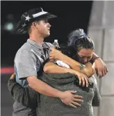  ?? Ethan Miller / Getty Images ?? People hug and cry outside the Thomas & Mack Center after a gunman rained down bullets on a country music festival on the Las Vegas Strip, leaving at least 59 people dead and hundreds injured.