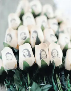  ?? JESSICA HILL / THE ASSOCIATED PRESS FILES ?? White roses bear the faces of victims of the Sandy Hook Elementary School shooting in Newtown, Conn.