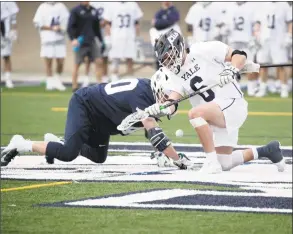  ?? Steve Musco / Yale Athletics ?? Yale’s TD Ierlan faces off with Penn State’s John Nostrant on Saturday. The Bulldogs beat the second-ranked Nittany Lions 14-13.