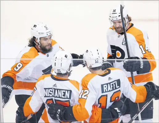  ?? FRANK GUNN — THE CANADIAN PRESS VIA AP ?? Flyers left wing Michael Raffl (12) is congratula­ted by teammates Ivan Provorov (9), Matt Niskanen (15) and Sean Couturier (14) after scoring on the Montreal Canadiens during the first period.