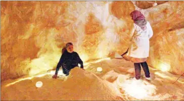  ?? AFP ?? A specialist covers the body of a client with salt at the Opal salt treatment centre in Libya’s eastern city of Benghazi on February 19.