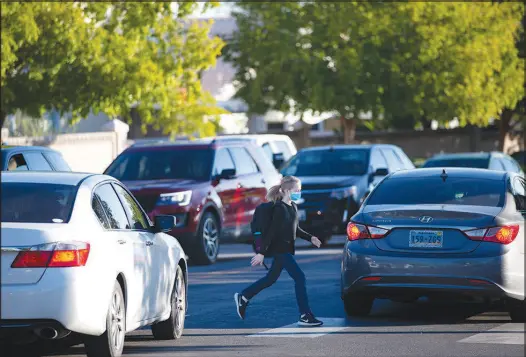  ?? PHOTOS BY STEVE MARCUS ?? A student uses the crosswalk Oct. 14 after being dropped off in front of Becker Middle School. Clark County School District police say they’re seeing more traffic violations in and around schools this fall than in previous years. School police have written roughly 2,000 tickets for moving violations so far this school year. For the same time frame in 2019, they had issued about 1,200 citations.