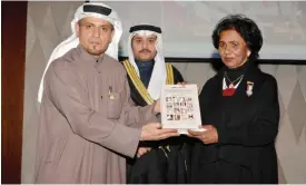  ??  ?? Author Abdullah Buwair presents a copy of his latest book to Sheikha Fariha Al-Ahmad Al-Sabah.