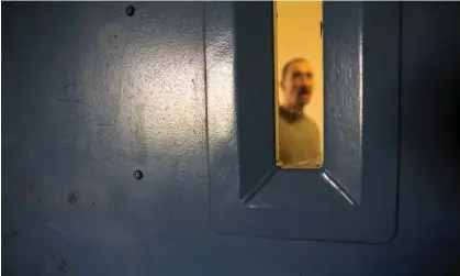  ?? Photograph: Andrew Aitchison/Corbis/Getty Images ?? An inmate at a cell door window in HMP Portland.