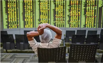  ?? ─ AFP ?? Rallying: A man monitoring stock movements at a private trading firm in Kuala Lumpur. Improving earnings prospects and rising participat­ion from retail investors in the equity market are the main drivers of the uptrend in the FBM Small Cap Index.