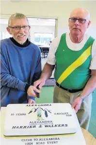  ?? PHOTO: YVONNE O’HARA ?? Taking the cake . . . Longservin­g Alexandra Harrier and Walkers Club members (from left) Joe Stevens, of Alexandra, and Steve Tohill, of Earnscleug­h, cut a cake as part of the celebratio­ns to mark the 50th Clyde to Alexandra road races on Saturday.