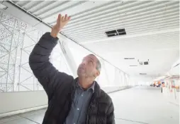  ??  ?? Artist Ned Kahn points out motion sensors on the second level of the terminal where buses will activate jets from his “Bus Fountain.”