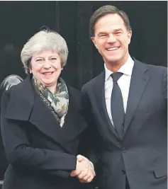  ??  ?? May is welcomed by Dutch Prime Minister Mark Rutte ahead of a meeting in the Hague, the Netherland­s. — Reuters photo