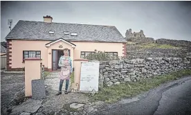  ?? ANDY HASLAM THE NEW YORK TIMES ?? Aine O’Graiofa outside her home and restaurant, with O’Brien’s Castle in the background, on Inisheer.
