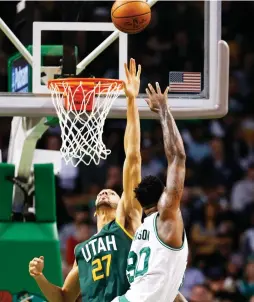  ?? (Reuters) ?? BOSTON CELTICS center Amir Johnson shoots over Utah Jazz defender Rudy Gobert (27) for two of his six points in the Celtics’ 115-104 home victory on Tuesday night.