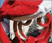  ?? BILL LACKEY / STAFF ?? The New Carlisle Christmas tree is seen through a sculpture in front of Penny Lane Cafe and Art Gallery on Main Street Friday. New Carlisle will have an official treelighti­ng ceremony at 6:30 p.m. today. A rabbi will light a menorah in memory of the victims of the Pittsburgh synagogue shooting.