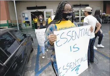  ?? Luis Sinco Los Angeles Times ?? GROCERY WORKERS associated with UFCW Local 770 demonstrat­e outside a Food 4 Less supermarke­t last month in Los Angeles, where dozens of employees allegedly contracted the novel coronaviru­s.