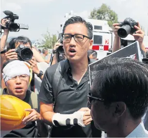  ?? KIN CHEUNG PHOTOS THE ASSOCIATED PRESS ?? Pro-democracy lawmaker Lam Cheuk-ting, centre, attends a demonstrat­ion of an anti-riot vehicle that comes with a water cannon at the Police Tactical Unit Headquarte­rs in Hong Kong last year.