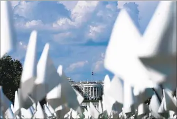  ?? Kent Nishimura Los Angeles Times ?? THE WHITE HOUSE is framed by small flags on Sept. 18, a tribute to Americans who had died of COVID-19. In this dispiritin­g close of President Biden’s first year, roadblocks stood in the way of all big things pending.