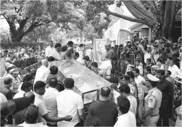  ??  ?? The body of Lankesh is brought to the Ravindra Kalakshetr­a cultural centre as people gather to pay their respects in Bangalore. — AFP photo