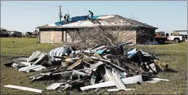  ?? WILLIAM WIDMER/THE NEW YORK TIMES ?? Austin Pearce, center, works with his uncles to replace a tarp over the weekend in Iowa, Louisiana. The tarp was initially installed on his roof after Hurricane Laura hit Aug. 27.