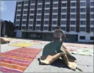  ?? MATT BORN — THE STAR-NEWS VIA AP ?? Blockade Runner Beach Resort concierge Rodney Vanek lays out rugs to dry in front of the hotel in Wrightsvil­le Beach, N.C., Tuesday. The hotel had water in some of the rooms from Hurricane Florence.