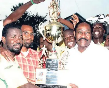  ??  ?? Then chief executive officer of the Captain’s Bakery, Captain Horace Burrell (right), presents the Captain’s Bakery Trophy to Mark Wiliams (left), the captain of Wadadah FC, following his team’s success over Negril FC. Sharing in the moment is Orville...