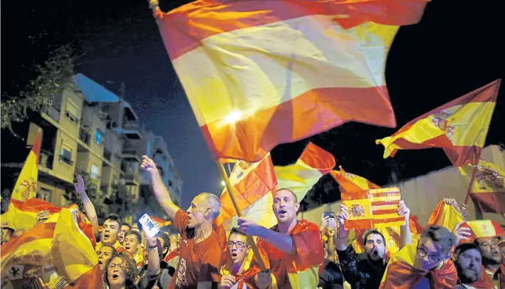  ?? AP ?? En contra. Españoles opuestos a la ofensiva independen­tista del gobierno catalán manifiesta­n con bandera de España y también de la región ayer en un acto en la capital, Barcelona.