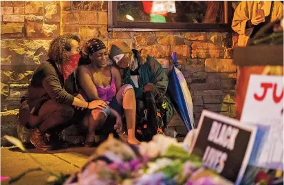  ??  ?? George Floyd’s girlfriend, Shawanda Hill (center), weeps near where he died in the custody of police in the US city of Minneapoli­s. Video of a handcuffed black man dying while an officer knelt on his neck has sparked fresh anger over police treatment of African Americans. — AFP