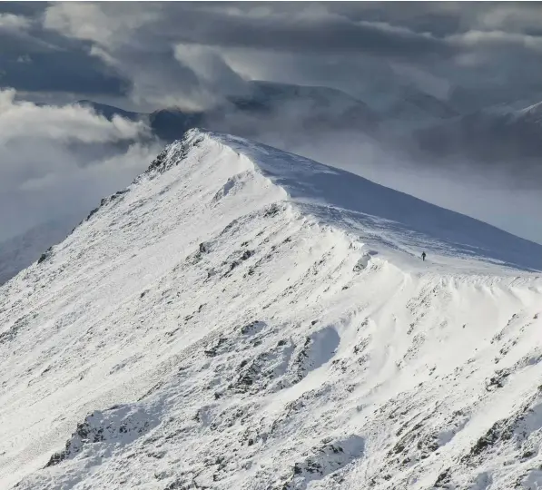  ??  ?? ABOVE A lone walker trudges through snow towards Blencathra’s Gategill Fell LEFT Terry directs hill farmer and walking guide Alison O’Neill before shooting a scene in Helvellyn