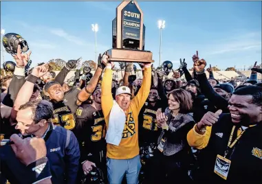  ?? Kennesaw state university athletics ?? Kennesaw State’s Brian Bohannon hoists his team’s 2021 Big South Conference trophy after toppling Monmouth 49-17 Saturday.