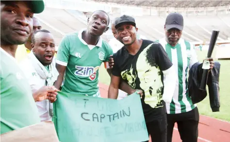  ??  ?? THROUGH THICK AND THIN ... CAPS United captain Hardlife Zvirekwi (second from right), who lost his arm in a car accident in Harare last week, gets a “Get Well Soon” message from his side’s fans during yesterday’s Castle Lager Premiershi­p soccer match...