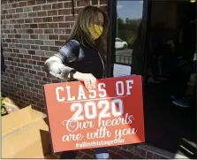  ?? BEN HASTY — MEDIANEWS GROUP ?? Denise Benfield holds a sign that she and Carrie McCarty had printed to honor graduating seniors who will not have a graduation ceremony because of the coronaviru­s outbreak.