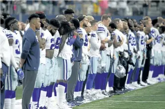  ?? RON JENKINS/THE ASSOCIATED PRESS ?? Dallas Cowboys players and staff stand on the sideline during the playing of the national anthem before Sunday’s game against the Green Bay Packers in Arlington, Texas.