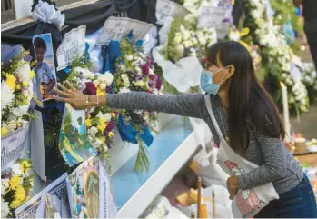  ?? WASON WANICHAKOR­N/AP ?? A woman touches a photo Sunday of one of the victims of a gun and knife attack in Uthai Sawan, Thailand. Ceremonies were held at three temples, where the bodies of the 36 victims were taken ahead of funeral rites Tuesday. A former police officer stormed a day care center Thursday before taking more lives as he fled. He then killed himself.