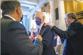  ?? J. Scott Applewhite Associated Press ?? SEN. ANGUS KING (I-Maine), center, speaks with Sen. Gary Peters (D-Mich.), left, as Sen. John Kennedy (R-La.) walks by on Friday inside the Capitol.