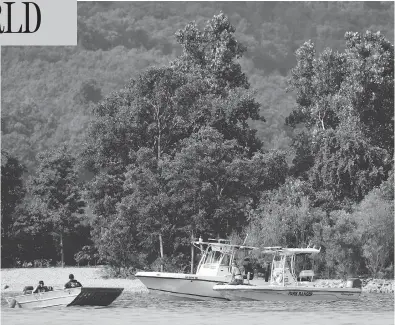  ?? CHARLIE RIEDEL/THE ASSOCIATED PRESS ?? Emergency workers patrol an area Friday near where a duck boat capsized the night before. Authoritie­s say the small boat sank to the bottom of Table Rock Lake in Branson, Mo., killing 17 people and injuring seven.