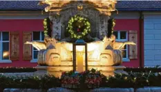  ?? Fotos: Roland Wiedenmann ?? Der Adventskra­nz auf dem Marienbrun­nen im Schlosshof in Oettingen hat einen Durchmesse­r von zehn Metern. Vier hängende Kränze zieren zudem die Mariensäul­e. Gerade am Abend kommt das Projekt zur Geltung.
