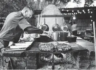  ?? DREW DECKMAN ?? Chef-owner Drew Deckman cooks on his outdoor grill at Deckman’s en el Mogor restaurant in Baja. Deckman will open his first U.S. restaurant in San Diego’s North Park in early 2024.