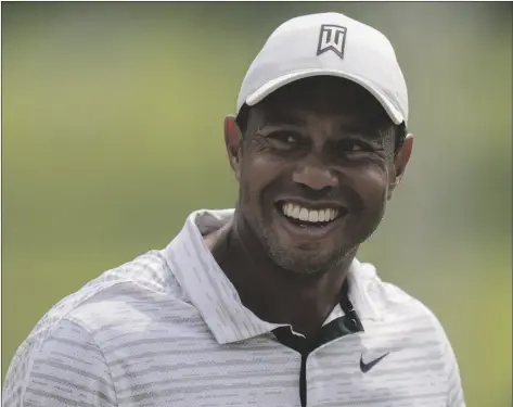  ?? ERIC GAY/AP ?? Tiger Woods smiles on the driving range before a practice round for the PGA Championsh­ip golf tournament Tuesday in Tulsa, Okla.