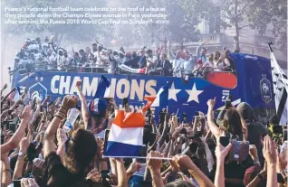  ??  ?? France’s national football team celebrate on the roof of a bus as they parade down the Champs-Elysee avenue in Paris yesterday after winning the Russia 2018 World Cup final on Sunday. –