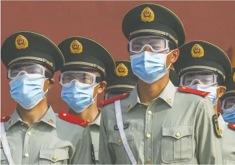  ?? KEVIN FRAYER/GETTY IMAGES ?? Chinese paramilita­ry police guard the entrance to the Forbidden City as it reopened to limited visitors Saturday in Beijing. Canada must stand up to China, which is a bully that thumbs its nose at global norms, laws and institutio­ns, writes Diane Francis.